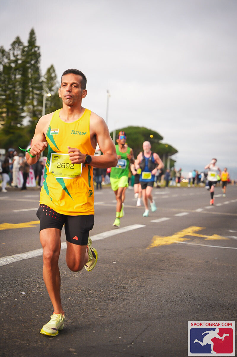 Vijay mid-stride in the yellow Fast&Up Indian singlet, focused, alone on the road.